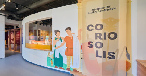 Entrée de l'ArchéoMusée Coriosolis. 2 personnages de l'Antiquité sont dessinés sur le mur et accueillent le visiteur.